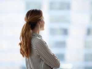 Unternehmen: Geschäftsfrau, die nachdenklich aus dem Fenster schaut