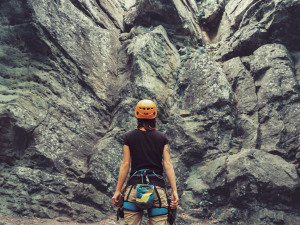 Datenschutz: Eine Frau steht vor einer Felswand und guckt nach oben